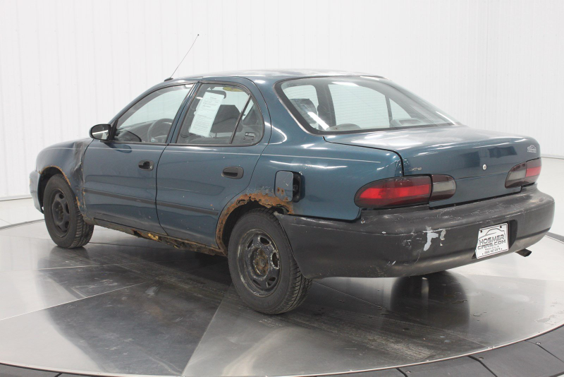 Illustration for article titled Even Rusty Beater Geo Prizms Deserve Nice Photo Shoots At The Dealership
